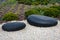 Zen garden dry landscape, or karesansui, japanese rock garden with black stones on white gravel for relaxation and