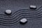 Zen garden with a wave lines in the sand with iregular stones