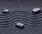 Zen garden with a wave lines in the sand with relaxing stones