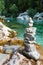 Zen-like arranged stack of stones at beautiful emerald colored river