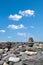 Zen-like stone pyramid on a wild volcanic shore with blue sky, clouds. Meditation, spiritual journey