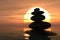 Zen pebbles stacked in sunset