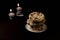 Zen Pile of chocolate Chips with stone piles in the back topped with candles on a dark environment