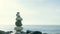 Zen pyramid of balanced stones on a background of the sea and blue sky. Concept of spiritual harmony, balance and