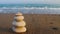 Zen stones and sea waves. The concept of harmony, stability, life balance, relaxation and meditation. A pyramid of stones on the s