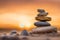 Zen stones stacked forming a pyramid on rocks, against the backdrop of the sunset, symbolizing harmony.