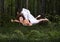 Zero gravity. Young beautiful woman flying in a dream in a summer forest