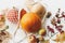 Zero waste Thanksgiving. Reusable shopping bag with pumpkins, apples, berries, nuts and autumn leaves on white wooden background.