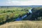 Zigzag river flows between summer valleys