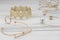 Zigzag shape golden bracelet between golden girl accessories on wooden table