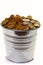 Zinc bucket of gold coins on a white background.