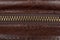 Zip fastener on a brown leather surface close-up