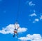 Zipline. A view of a man sliding on a steel cable against a beautiful blue sky. Extreme and active rest.