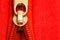 Zipper partly open binding together two layers of red fabric textile and red leather under high magnification
