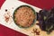 Zira rice lies in an oriental plate. dark rice lies on an oriental background, a golden tablecloth, a wooden cutting board next to