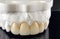 Zirconia crowns with all porcelain baked. Close-up view of dental layout of upper veneers of teeth prosthesis, isolated on black