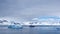 Zodiac and expedition cruise ship among icebergs in a bay in Antarctica