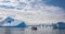 Zodiac full of intrepid tourists  amidst icefield of giant icebergs in Disko Bay, Greenland