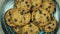 Zoom out fresh brown oatmeal cookies with chocolate on black plate. Top view