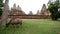 Zoom Out - Ox Eating Grass with Temple Remains in the Background - Angkor Wat Temple Cambodia