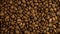 Zoom out rotating of roasted dark coffee beans.