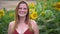 Zoom out shot of carefree Caucasian woman smiling in beautiful sunflower field during spring season