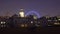 Zoom-out, time-lapse of the London Eye at night.