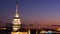 Zoom out timelapse of Maiden Tower or Kiz Kulesi with floating tourist boats on Bosphorus in Istanbul at night