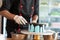 Zoom of pastry chef hand using rubber gloves smooth over melted chocolate on round blue cake