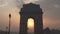 zoom in shot of the sun and india gate at sunrise in new delhi