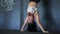 Zoom in to concentrated sportswoman doing handstand push ups in gym leaning feet on wall. Portrait of fit strong