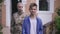 Zoom in to desperate teenage boy with USA flag looking at camera as blurred sad military mother caressing hair standing