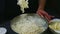 Zoom in at of woman hands by whisk mixing white flour with soft dough