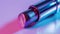 A zoomedin shot of a lipstick tube showing off its iridescent pink casing. Inside the tube the lipstick is a deep plum