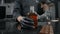 Zooming shot: chef in black apron and gloves opens the bottle of cognac and bung flies away in slow motion, opening the