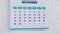 Zooming in the Thanksgiving date of a wall calendar 2021 and the male hands marking it with a blue marker