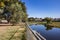 Zoquipan dam with low water next to Avila Camacho public park against blue sky