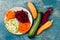 Zucchini, carrot, sweet potato and beetroot noodles on a plate. Top view, overhead. Blue rustic background.