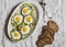 Zucchini fritters with fried quail eggs. Delicious breakfast or snack on a gray table, top view.