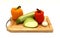 Zucchini, head of garlic and a pair of ripe yellow and orange sweet peppers on a cutting board on a light background.