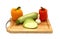 Zucchini, head of garlic and a pair of ripe yellow and orange sweet peppers on a cutting board on a light background.