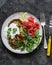 Zucchini and latkes with smoked salmon, sour cream and arugula. Delicious breakfast, brunch, tapas, appetizer on a dark background