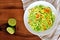 Zucchini noodle dish with lime on wood background