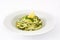 Zucchini noodles with pesto sauce on white background