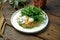 Zucchini pancake with Greek yogurt, arugula and poached egg on a wooden background. Tasty and healthy breakfast