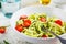 Zucchini pasta with pesto, avocado and tomatoes in white plate. Raw vegan food concept