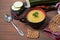 Zucchini and pumpkin soup on a brown wooden background, sliced zucchini on a wooden cutting Board, grain crackers on a red napkin