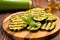 zucchini slices with charred grill marks on a bamboo board