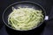 Zucchini spaghetti being cooked in a frying pan