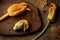 Zucchini yellow flowers on solid wood cutting board, tree bark on rust background.